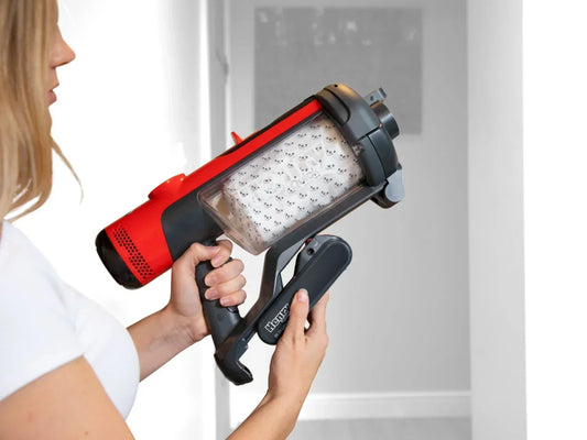 Woman holding the body of the Henry Quick, a cordless handheld vacuum 
